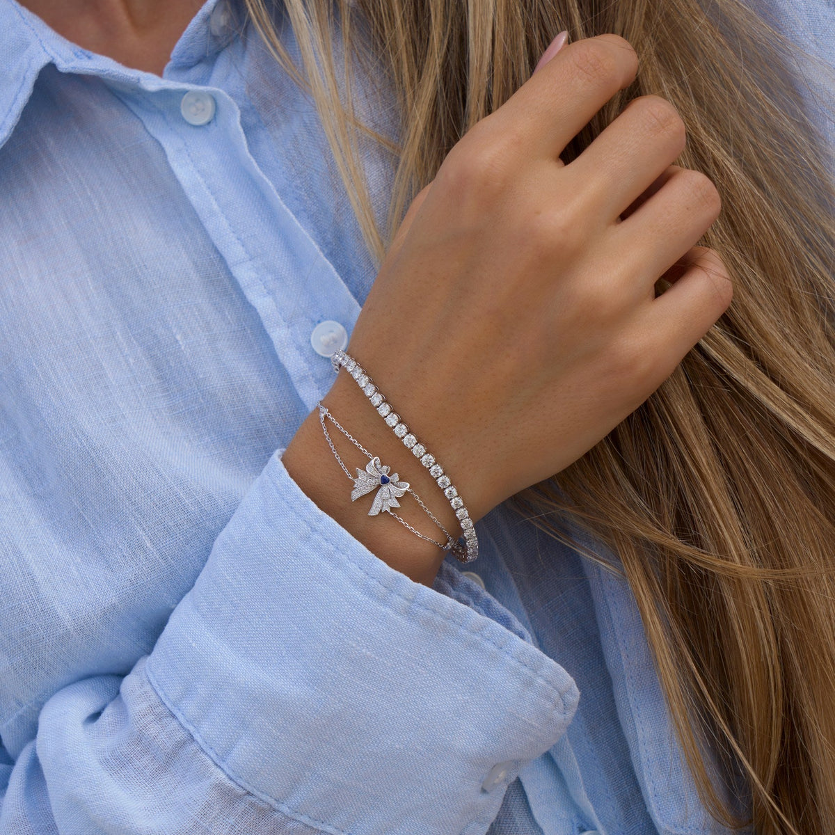 Person wearing a silver bracelet with a light blue shirt