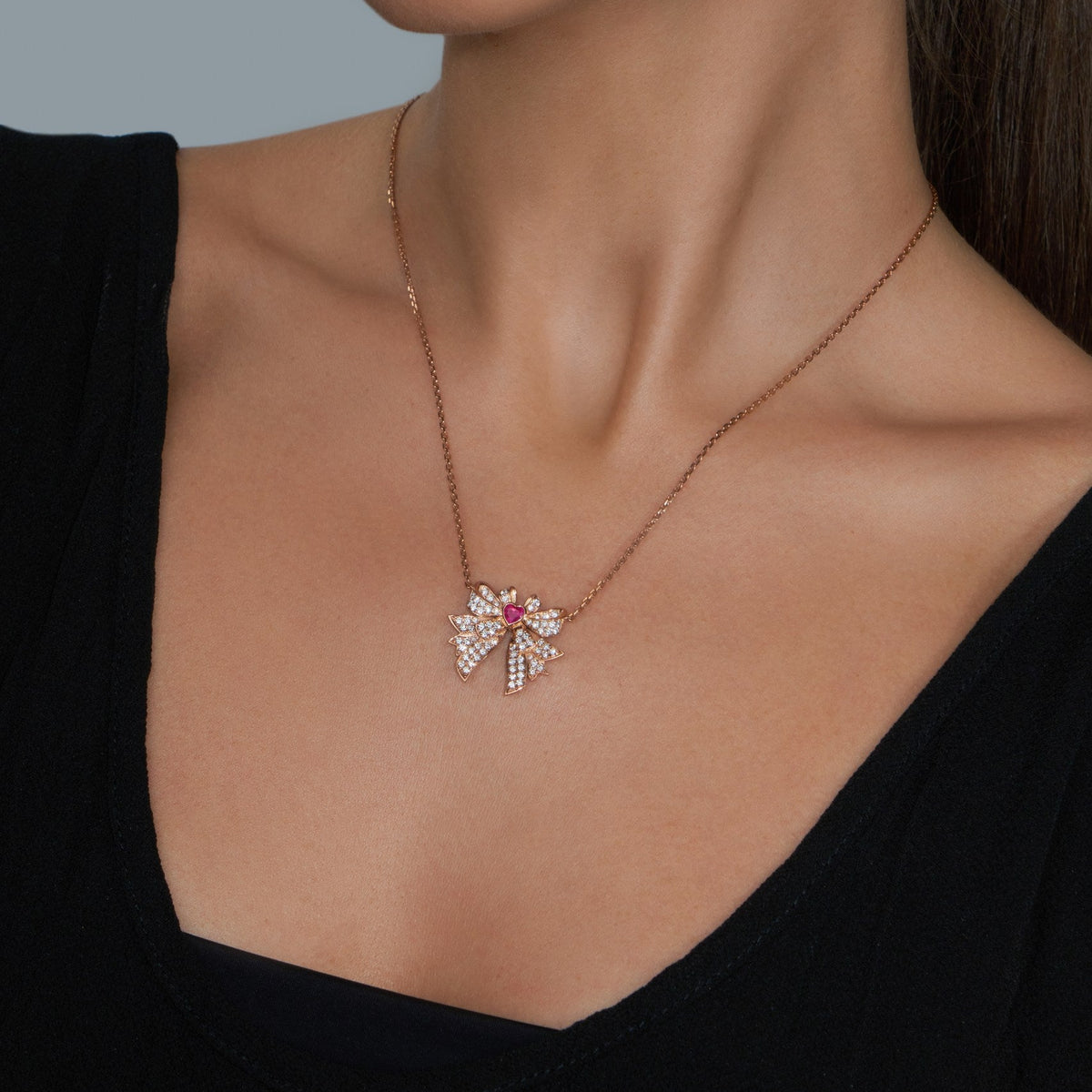 Necklace with a pendant worn by a person against a neutral background